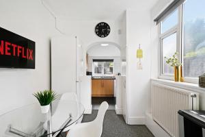 a dining room with a glass table and white chairs at Contractor Group relocation accommodation Birmingham in Birmingham