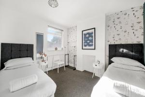 sypialnia z 2 łóżkami, 2 stołami i oknem w obiekcie Group Stays Birmingham w Birmingham