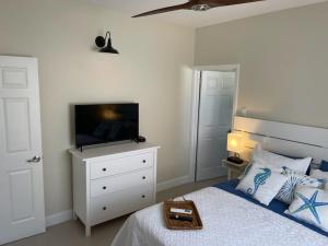 a bedroom with a bed and a tv on a dresser at Starr & Adams Caribbean Oasis in Point