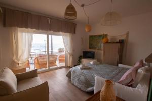 een slaapkamer met een bed en uitzicht op de oceaan bij TERRACINA SEA FRONT FANTASTIC APARTMENT WITH ONE CAR PRIVATE OPEN PARKING in Terracina