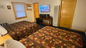 een hotelkamer met 2 bedden en een televisie bij Fawndale Lodge in Redding