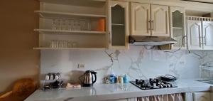 cocina con armarios blancos y encimera en Departamento en Cuenca, 3 Habitaciones y parqueo gratis, en Cuenca