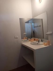 a bathroom with two sinks and a large mirror at Bungalows Sol y Mar in Canoas De Punta Sal