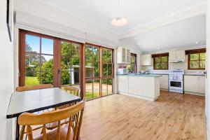 a kitchen with a table and chairs in a room at 12 Bluewater Drive Narooma in Narooma