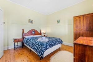 a bedroom with a bed with a blue and white comforter at 12 Bluewater Drive Narooma in Narooma