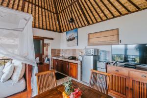 cocina con mesa y sillas en una habitación en Villa Mimpi Manis, en Nusa Lembongan