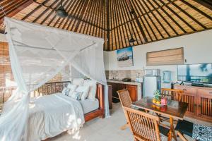 a bedroom with a bed and a table and a kitchen at Villa Mimpi Manis in Nusa Lembongan