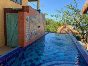 einen Pool in einem Haus mit einer Kachelwand in der Unterkunft Tree House by the Ocean ( for 2 guests) in Calatagan