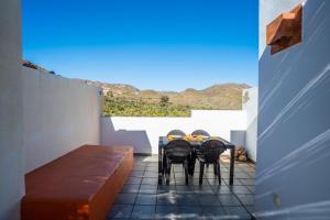 una mesa con 4 sillas en un balcón con vistas en Trendy Homes Casa Nerida, en Rodalquilar
