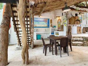 eine Küche und ein Esszimmer mit einem Tisch und Stühlen in der Unterkunft Tree House by the Ocean ( for 2 guests) in Calatagan