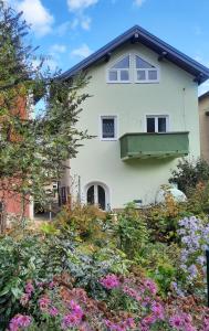 a white house with a balcony and flowers at FeWo An der Bruecke in Solnhofen