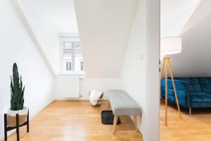 格拉茲的住宿－Comfy Downtown Loft - Self Check-in - Centre of Graz，客厅配有蓝色的沙发和桌子