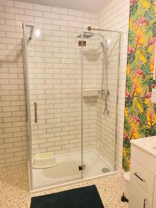 a shower with a glass door in a bathroom at A Perfect Two Bedroom House for a Family Stay in Havering atte Bower