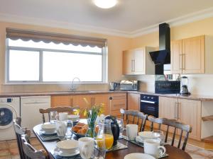 a kitchen with a table with food on it at Cairncroft Cottage in Colfin
