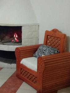 a wooden chair with a fireplace in a room at Hostal la nube in San Cristóbal de Las Casas