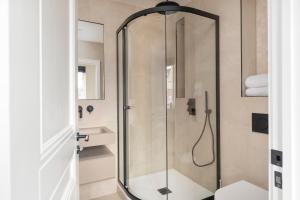 La salle de bains est pourvue d'une douche avec une porte en verre. dans l'établissement Skyvillion - COZY LARGE 4 Bed Apartments in London Enfield, Mins to Tube Station, Free Wi-Fi, à Cockfosters