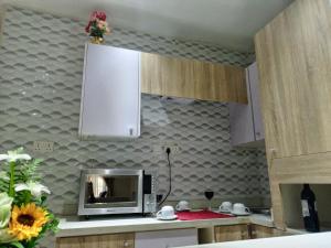 uma cozinha com um micro-ondas num balcão com uma parede em Carlton Swiss Grand Hotel em Enugu
