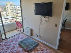 Habitación con TV de pantalla plana en la pared en Delpino Propiedades - 7 Norte a pasos de San Martín, en Viña del Mar