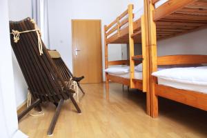 Zimmer mit 2 Etagenbetten und 2 Stühlen in der Unterkunft Hostel Kronotop in Triglav National Park in Log pod Mangartom