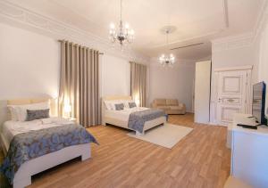 a bedroom with two beds and a living room at Vila Ferdinand Modern Rooms In Tirana's Center in Tirana