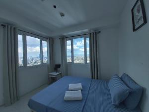 a bedroom with a blue bed with two pillows on it at Condo Studio Luxe in Princeton Residences in Manila