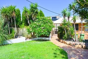 uma casa com palmeiras e um jardim de relva em Lakeside Luxury em Gorokan