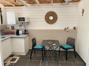 a kitchen with a table and chairs and a counter at Kaza Mango in Sainte-Luce