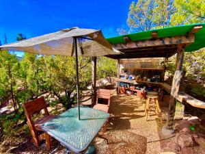 a patio with an umbrella and a table and chairs at The Chi-Treehouse at Sunny Mellow Eco Villa in Tijeras
