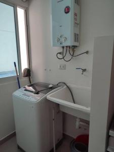 a bathroom with a sink and a washing machine at Departamento en el centro de Santa cruz. in Santa Cruz de la Sierra