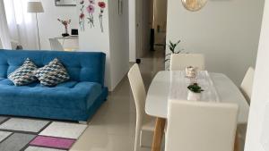 sala de estar con sofá azul, mesa y sillas en Beautiful Apartment Near Cali & Airport 2 bed 2 bath 2 pax en Yumbo