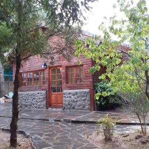 Casa con puerta de madera y pared de piedra en Cabaña Ayelen en Esquel