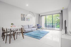 a white living room with a table and a couch at G3 Apartment in Brisbane