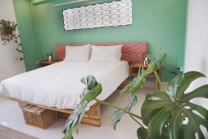 1 dormitorio con 1 cama y una maceta en Baan Pila, en Luang Prabang