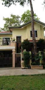 a house with a tree in front of it at Charming Getaway @ The City of Pines in Baguio