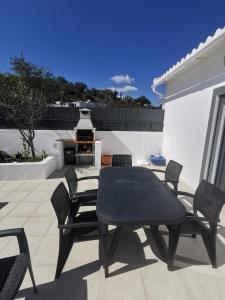 un patio con tavolo, sedie e griglia di Casas Caiado Two Houses with swimming POOL a Faro