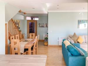 a living room with a blue couch and a table at Ardstinchar Mews in Ballantrae