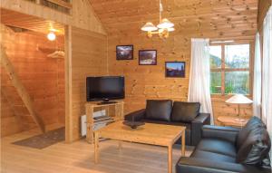 a living room with a couch and a tv in a cabin at Amazing Home In Vallavik With House Sea View in Vangsbygd