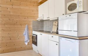 a kitchen with white appliances and wooden walls at 3 Bedroom Pet Friendly Home In Vallavik in Vangsbygd