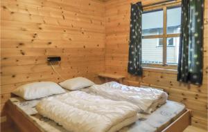 a bedroom with two beds in a wooden room at 3 Bedroom Pet Friendly Home In Vallavik in Vangsbygd