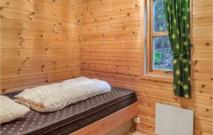 a log cabin with a bed in a room with a window at 3 Bedroom Pet Friendly Home In Vallavik in Vangsbygd +4 photos