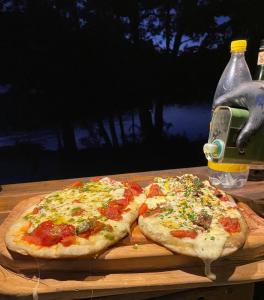 Dos pizzas encima de una tabla de cortar de madera en PUNTO PUERTO PATRIADA en El Hoyo