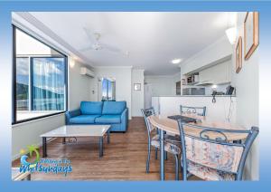 a living room with a blue couch and a table at Marina views at Airlie 10F - 1 bedroom in Airlie Beach