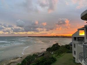 a view of the beach at sunset from a condo at Monterey Lodge - Unit 18, 27 Warne Terrace, Kings Beach Caloundra in Caloundra