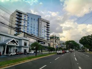 汕埠的住宿－Alojamiento River Merendón，街道上拥有建筑和汽车的城市街道