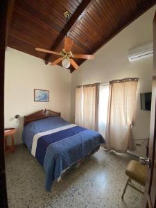 a bedroom with a bed and a ceiling fan at Villas del Mar in La Ceiba