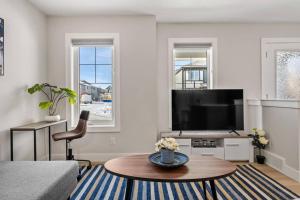 a living room with a tv and a coffee table at Stylish 3BR Townhouse by Airport in Calgary