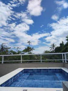 a swimming pool on top of a house with a blue sky at Recanto Dubay in Caraguatatuba