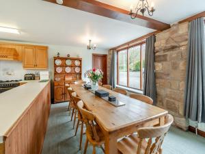a kitchen and dining room with a wooden table and chairs at The Haybarn - Uk42935 in Rosedale Abbey