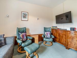 a living room with two chairs and a tv at The Haybarn - Uk42935 in Rosedale Abbey