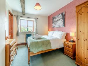 a bedroom with a large bed and a window at The Haybarn - Uk42935 in Rosedale Abbey
